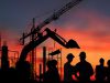 Silhouette engineer standing orders for construction crews and Excavator and machinery in an outdoor mine
