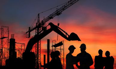 Silhouette engineer standing orders for construction crews and Excavator and machinery in an outdoor mine